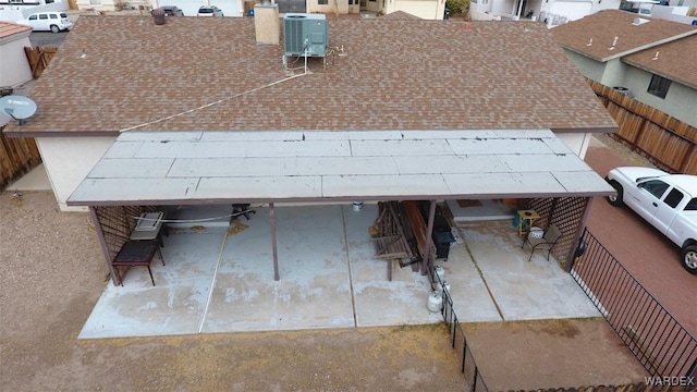 exterior details featuring a shingled roof, fence, and central air condition unit