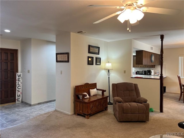 sitting room with ceiling fan, baseboards, visible vents, and light colored carpet