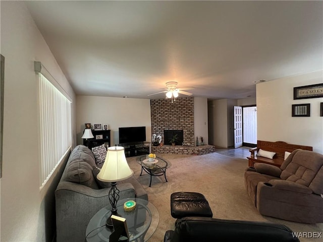 living room with ceiling fan, carpet floors, and a brick fireplace