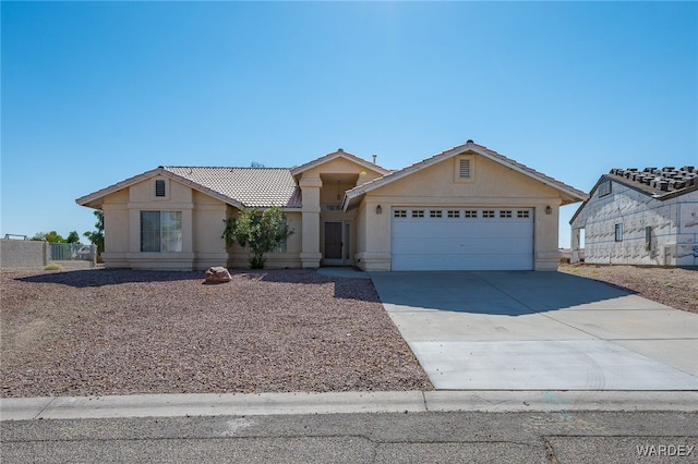 view of front of house featuring concrete driveway, a tiled roof, an attached garage, and stucco siding