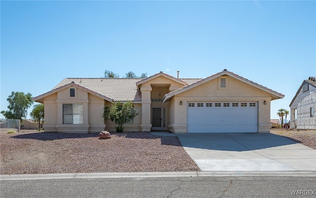 view of front of home with a garage, a tile roof, concrete driveway, and stucco siding