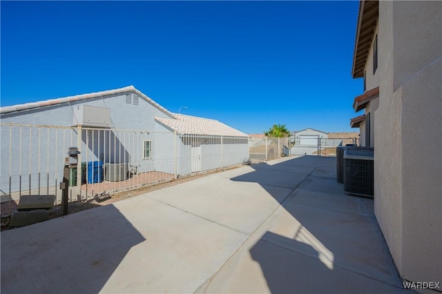 view of patio / terrace featuring fence private yard, an outbuilding, and central AC unit