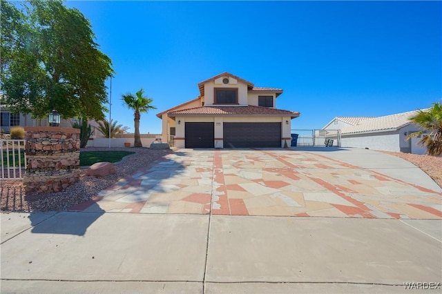 mediterranean / spanish-style house with stucco siding, concrete driveway, fence, a garage, and a tiled roof