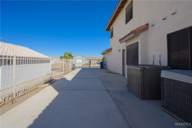 view of patio / terrace featuring central AC unit, fence, and a gate