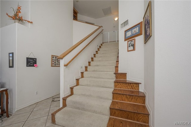 stairs featuring tile patterned flooring, visible vents, and baseboards