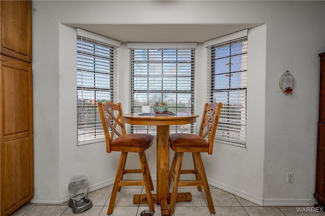 dining area with baseboards and light tile patterned floors