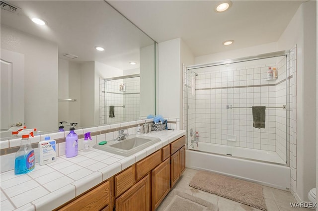 bathroom featuring shower / bath combination with glass door, visible vents, toilet, vanity, and tile patterned flooring