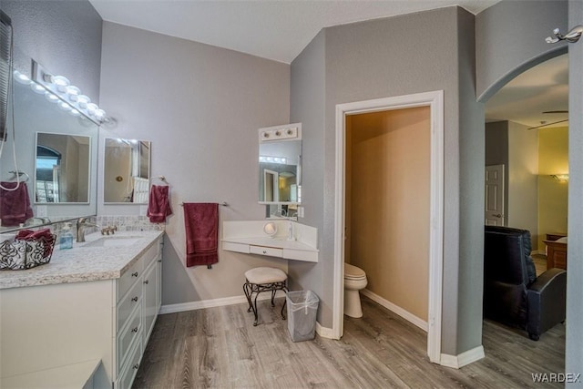 full bath featuring baseboards, toilet, wood finished floors, and vanity