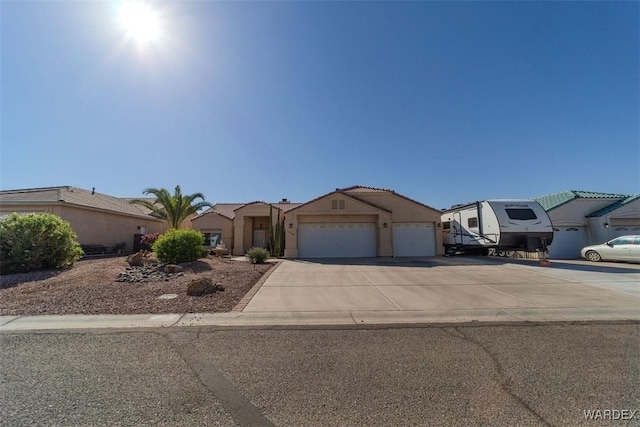 view of front of property featuring a garage, driveway, and stucco siding