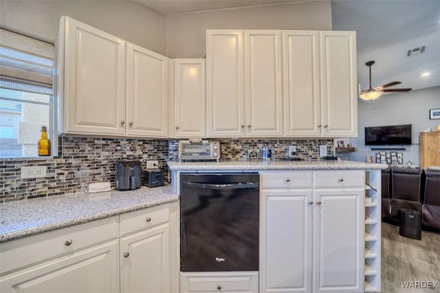 kitchen featuring tasteful backsplash, visible vents, open floor plan, dishwasher, and white cabinets