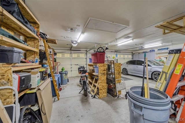 garage featuring a garage door opener and visible vents