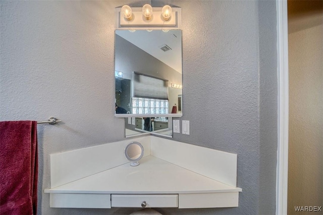 bathroom with visible vents and a textured wall