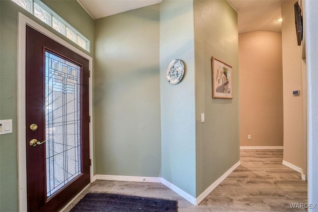 entryway with baseboards and wood finished floors