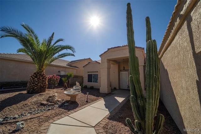 exterior space with stucco siding and fence