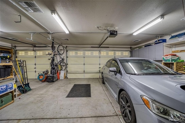 garage with visible vents and a garage door opener