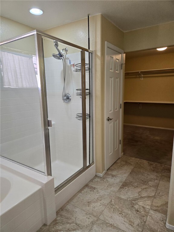 3836 Heather Ave, Kingman, AZ 86401 - bathroom featuring a stall shower, a walk in closet, a bathtub, and recessed lighting