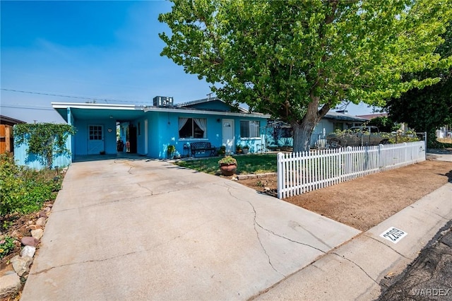 view of front of house featuring driveway, a carport, and fence