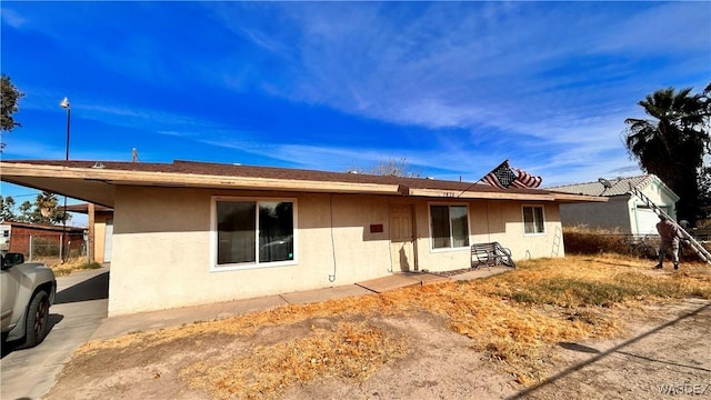 back of house with fence and stucco siding