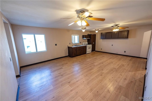 kitchen featuring light countertops, dark brown cabinets, light wood-type flooring, and white range with gas cooktop