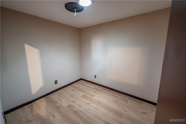 spare room with light wood-style floors and baseboards