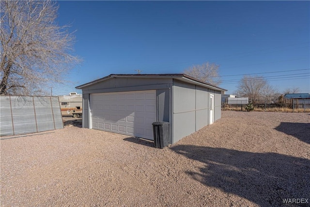 detached garage featuring fence