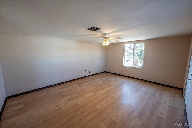 spare room with visible vents, ceiling fan, light wood-style flooring, and baseboards