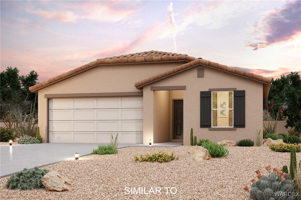 mediterranean / spanish-style home with concrete driveway, an attached garage, a tile roof, and stucco siding