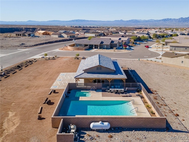 pool with a patio, a residential view, and a mountain view