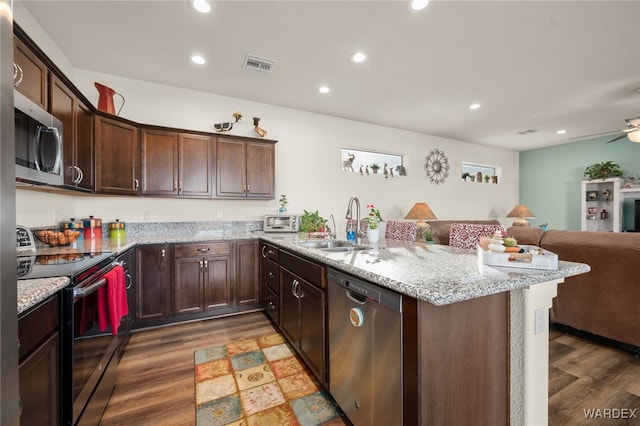 kitchen with open floor plan, stainless steel appliances, dark wood finished floors, and visible vents