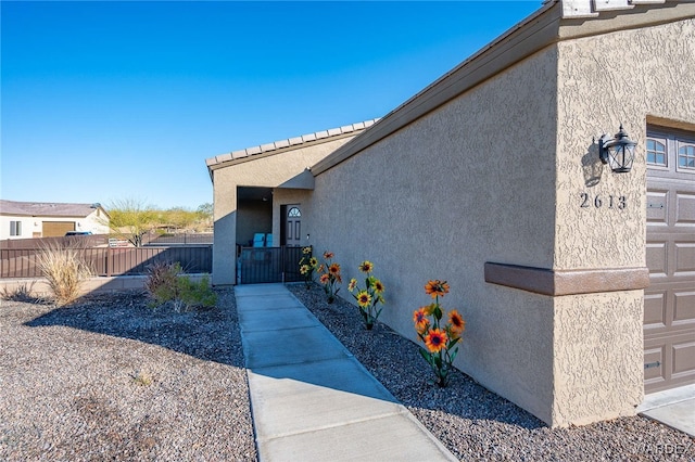 view of home's exterior with fence and stucco siding