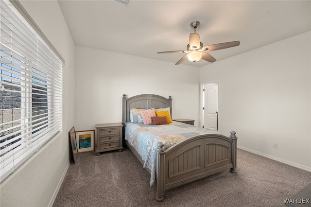 bedroom featuring dark carpet, a ceiling fan, and baseboards