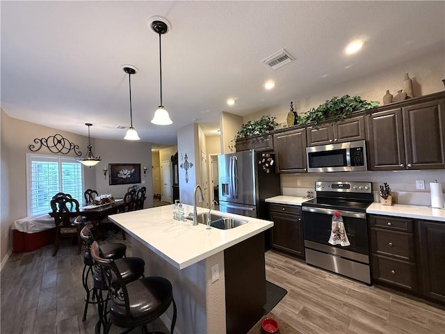 2600 Slide Mountain Loop, Bullhead City, AZ 86442 - kitchen featuring appliances with stainless steel finishes, light countertops, dark brown cabinets, and light wood-style floors
