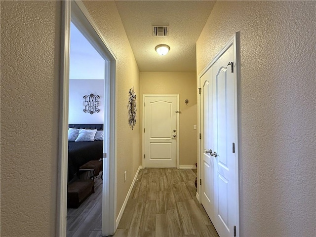 2600 Slide Mountain Loop, Bullhead City, AZ 86442 - hall featuring a textured wall, wood finished floors, and a textured ceiling