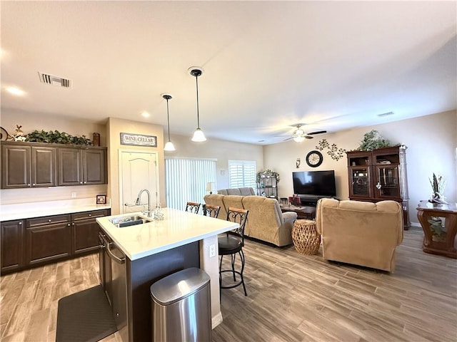 2600 Slide Mountain Loop, Bullhead City, AZ 86442 - kitchen with a ceiling fan, a kitchen bar, dark brown cabinets, light countertops, and light wood-style floors