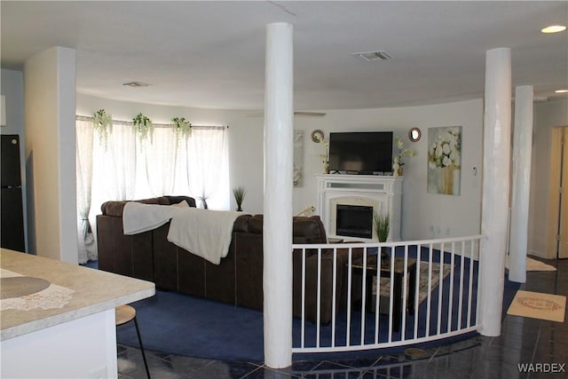 living area featuring recessed lighting, visible vents, and a fireplace