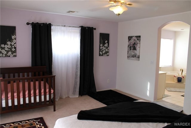 bedroom featuring arched walkways, visible vents, ceiling fan, and baseboards