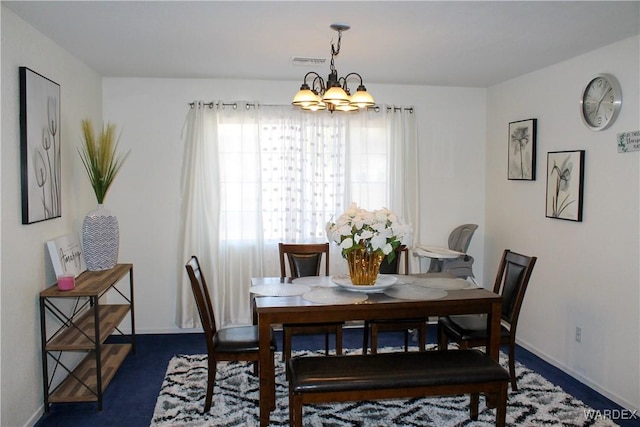 dining area featuring baseboards, visible vents, and an inviting chandelier