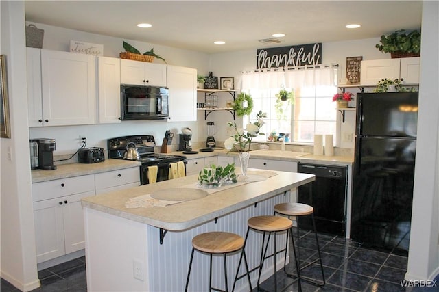 kitchen featuring black appliances, light countertops, and white cabinets