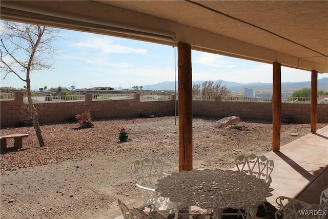 view of yard with a fenced backyard, a mountain view, and a patio