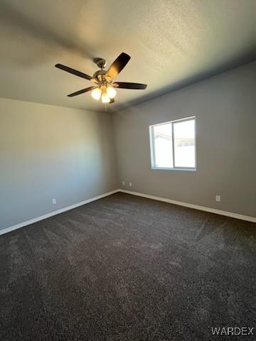 3515 E Lum Ave, Kingman, AZ 86409 - empty room with baseboards, ceiling fan, and dark colored carpet