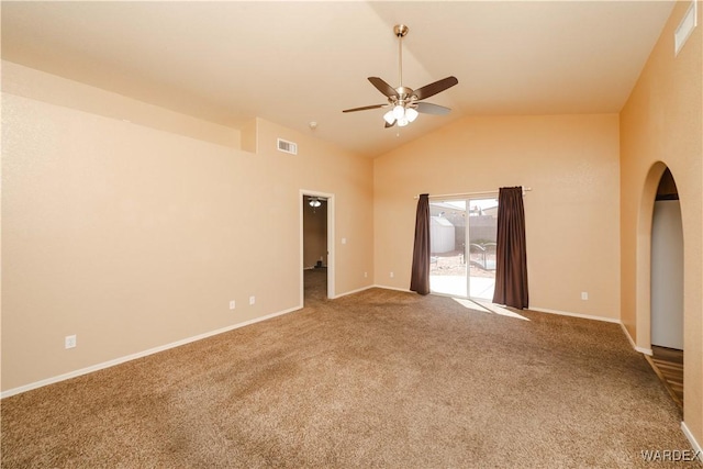 carpeted empty room featuring visible vents, lofted ceiling, arched walkways, baseboards, and ceiling fan