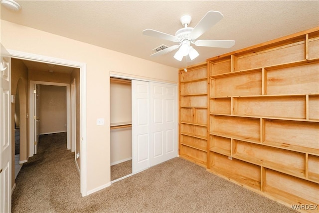 unfurnished bedroom with visible vents, a textured ceiling, a closet, carpet, and baseboards