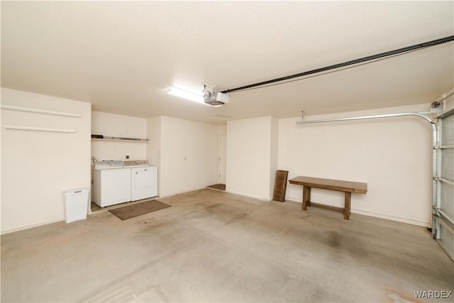 garage with washing machine and dryer and a garage door opener