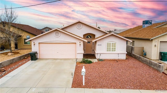 ranch-style home with stucco siding, driveway, an attached garage, and fence