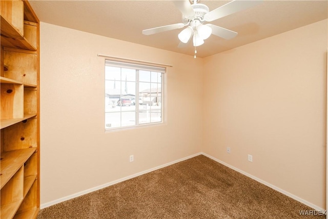 carpeted empty room featuring a ceiling fan and baseboards