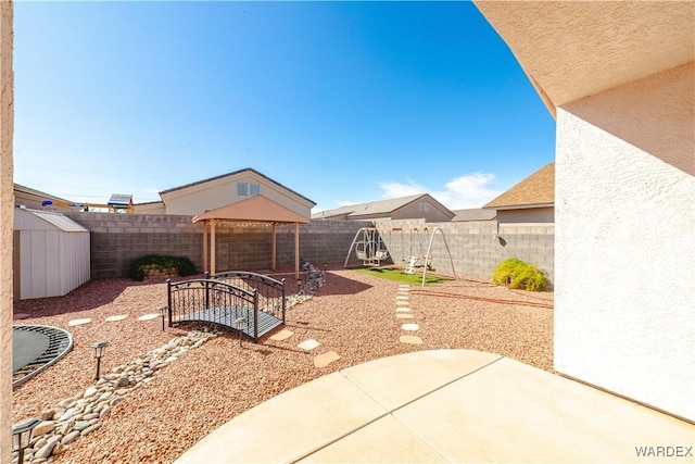 view of yard featuring a storage unit, a patio, an outdoor structure, and a fenced backyard