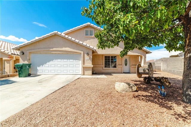 3048 Mallory Loop, Kingman, AZ 86401 - view of front facade with an attached garage, driveway, and stucco siding
