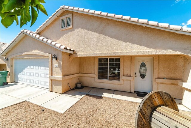 3048 Mallory Loop, Kingman, AZ 86401 - view of front of property featuring an attached garage, stucco siding, a tiled roof, and driveway