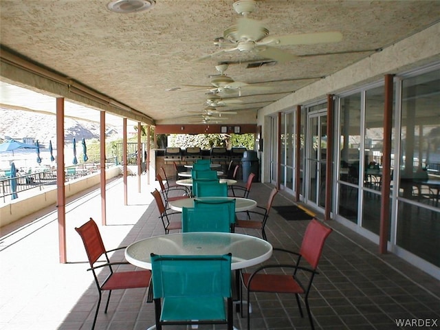 sunroom / solarium featuring ceiling fan