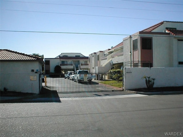 view of front of home with fence, a gate, and stucco siding